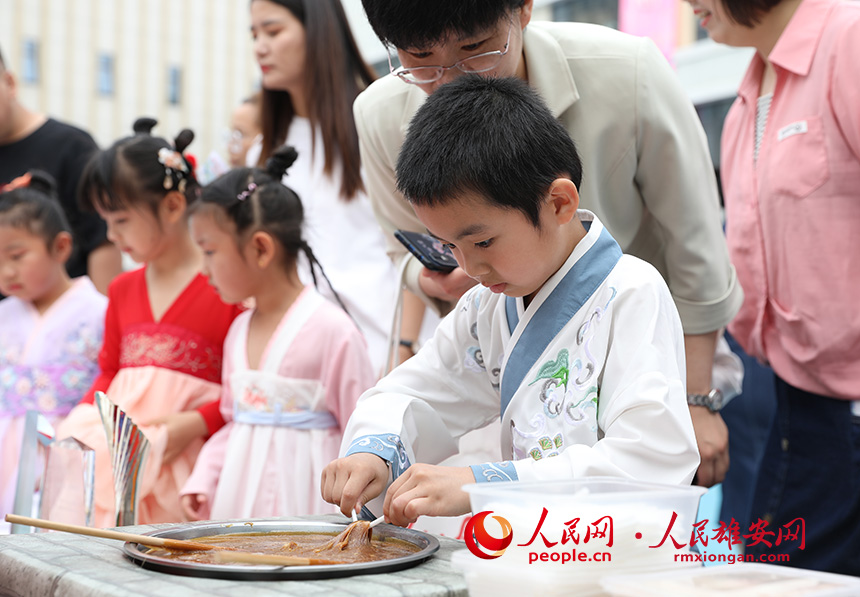 5月31日，雄安容和樂(lè)安幼兒園舉辦傳統(tǒng)文化游園活動(dòng)?；顒?dòng)邀請(qǐng)了雄安當(dāng)?shù)胤沁z文化傳承人走進(jìn)幼兒園，與孩子和家長(zhǎng)交流互動(dòng)。通過(guò)現(xiàn)場(chǎng)接觸非遺項(xiàng)目，讓孩子們零距離認(rèn)識(shí)非遺、熟悉非遺，感受非遺之美。人民網(wǎng) 李兆民攝