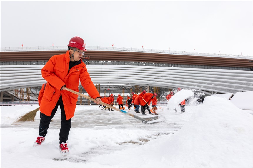 雄安體育中心項(xiàng)目組織建設(shè)者開展清雪除冰工作。北京城建供圖